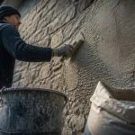 Enduit à la chaux facade : artisan applique un gobetis à la truelle