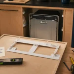 Installation porte lave vaisselle encastrable : façade à percer et niveau de fixation
