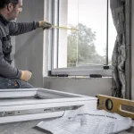 Prix remplacement fenetre : artisan installe une fenêtre neuve