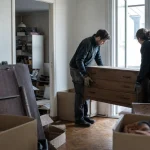 Vide appartement : équipe de débarras avec cartons et meubles