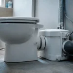 Fonctionnement sanibroyeur : WC compact, tuyau et clapet anti-retour.